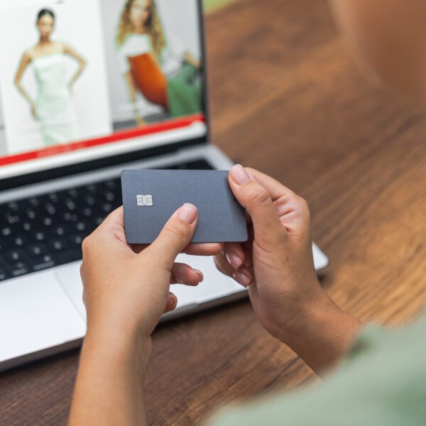 Female hands with credit card near laptop online fashion store, convenient online clothing shopping