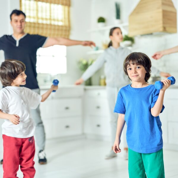 Fitter, healthier, happier. Cute little latin boy smiling at camera, exercising with dumbbell while
