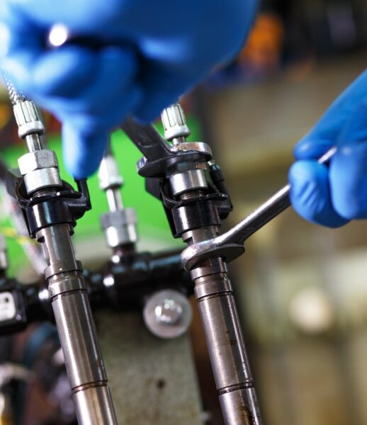 Professional mechanic testing diesel injector in his workshop.