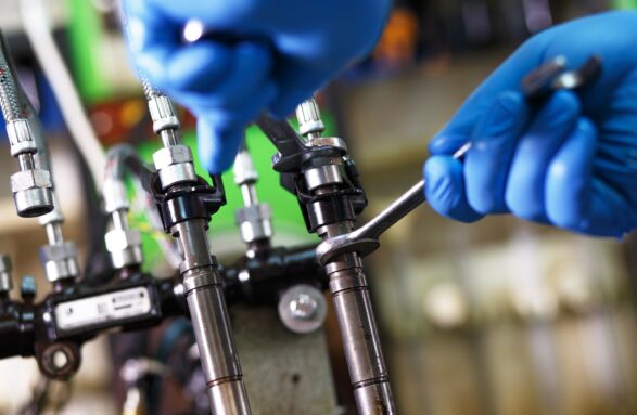 Professional mechanic testing diesel injector in his workshop.