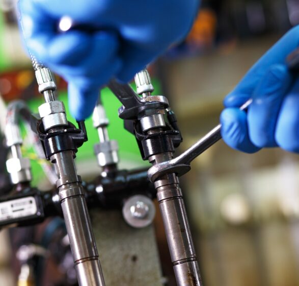 Professional mechanic testing diesel injector in his workshop.