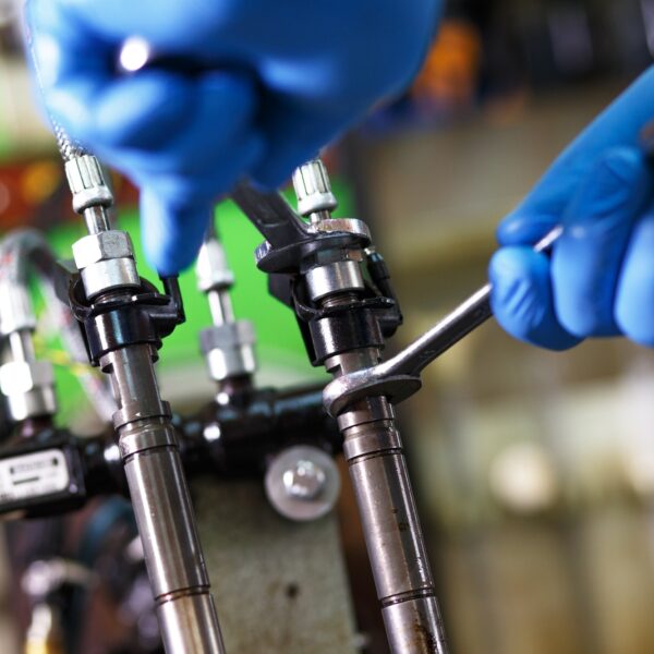 Professional mechanic testing diesel injector in his workshop.