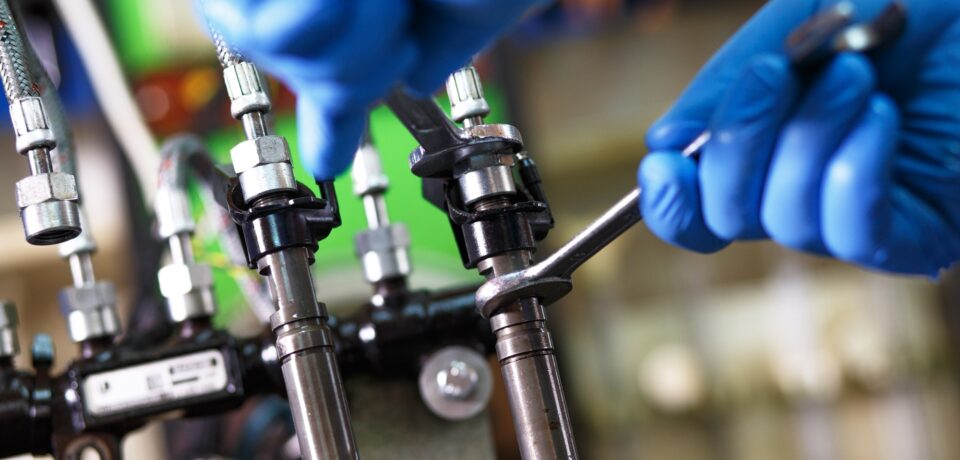 Professional mechanic testing diesel injector in his workshop.